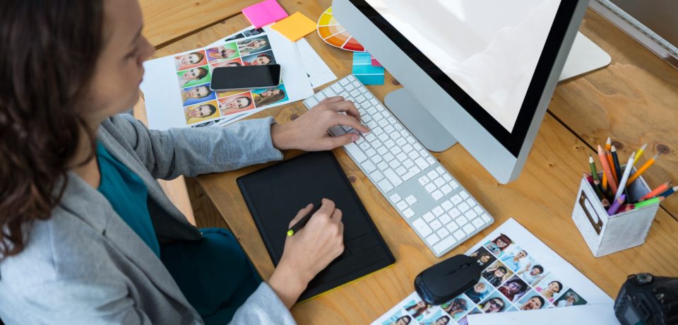 Female graphic designer using graphics tablet at desk